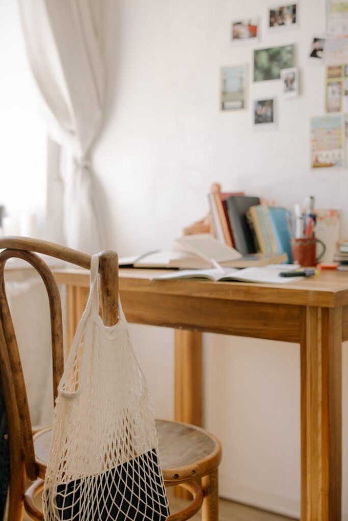 pexels-photo-4769470 Rustic wooden desk in cozy home office with books and net bag. Ideal for studying or working.